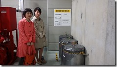 港南台ひの特別支援学校に保管されている放射能汚染汚泥の入ったドラム缶の前で、あさか由香さんとみわ智恵美